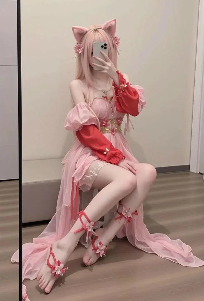 Gái xinh cosplay mèo màu hồng chụp selfie trước gương với váy pastel, tai mèo và phụ kiện hoa
