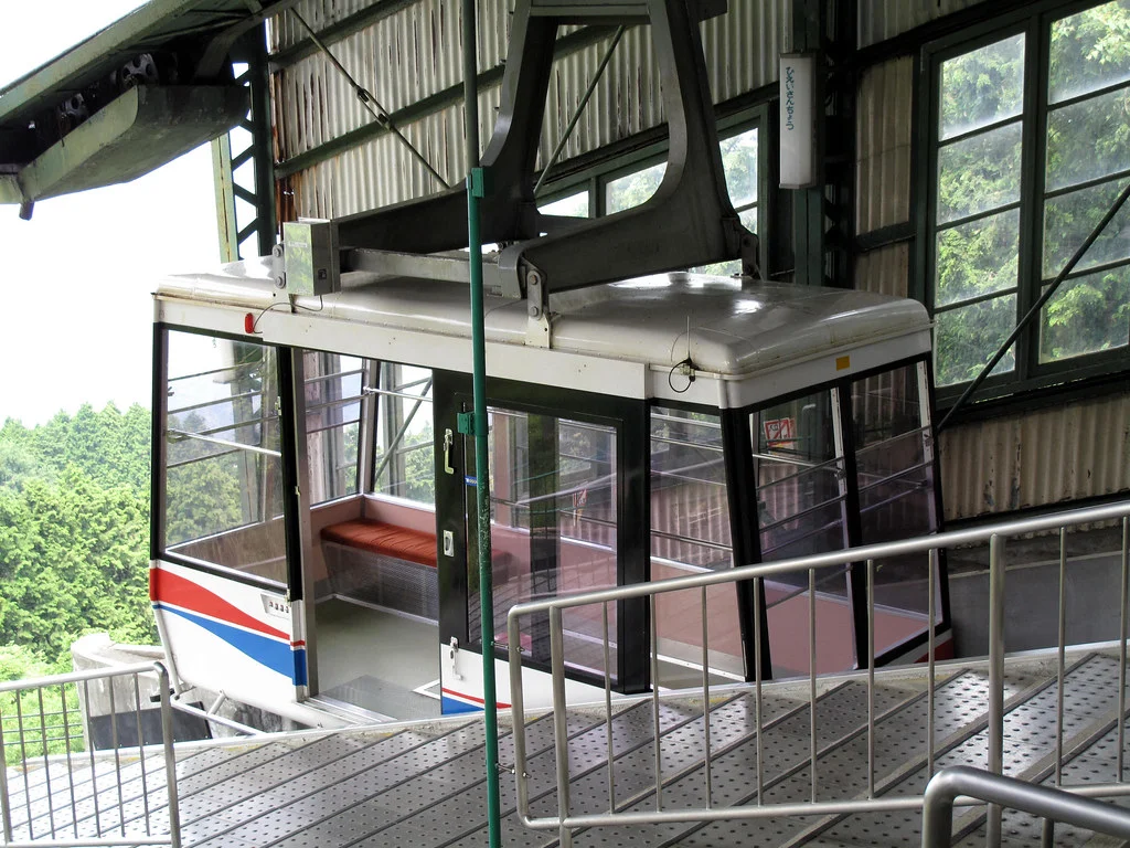 Ga cáp treo với cabin giữa khung cảnh rừng núi xanh tươi